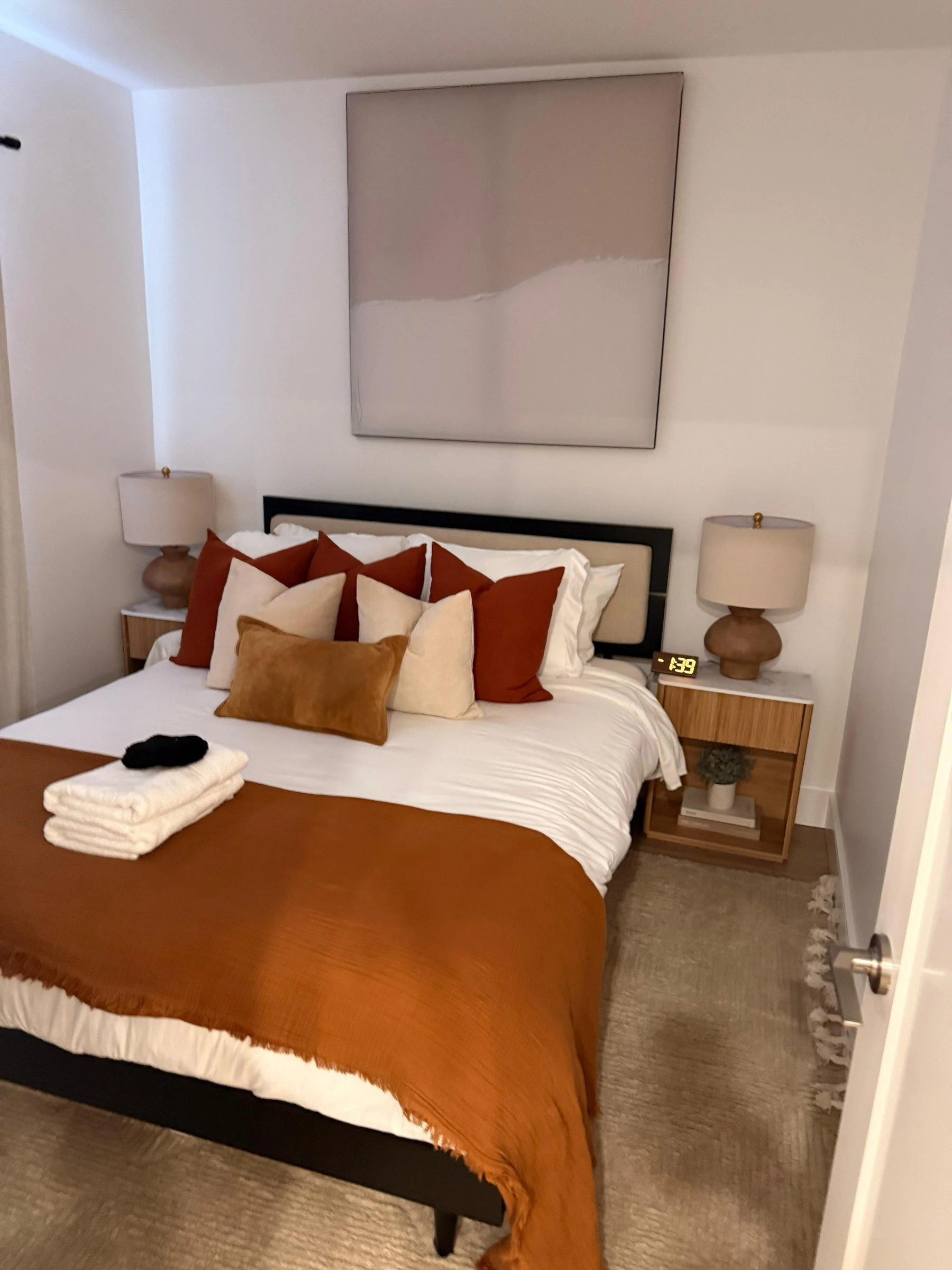 Same Airbnb bedroom after AMH turnover, bed made with fresh linens and guest towels