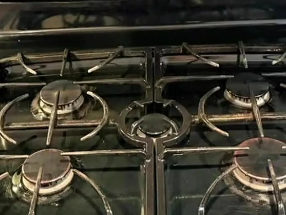 Same gas stove top after AMH deep cleaning, grates and burners clean