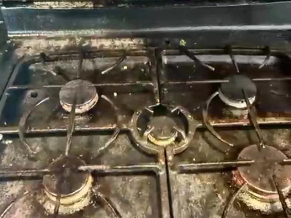 Gas stove top before cleaning, with burnt-on grease and food residue