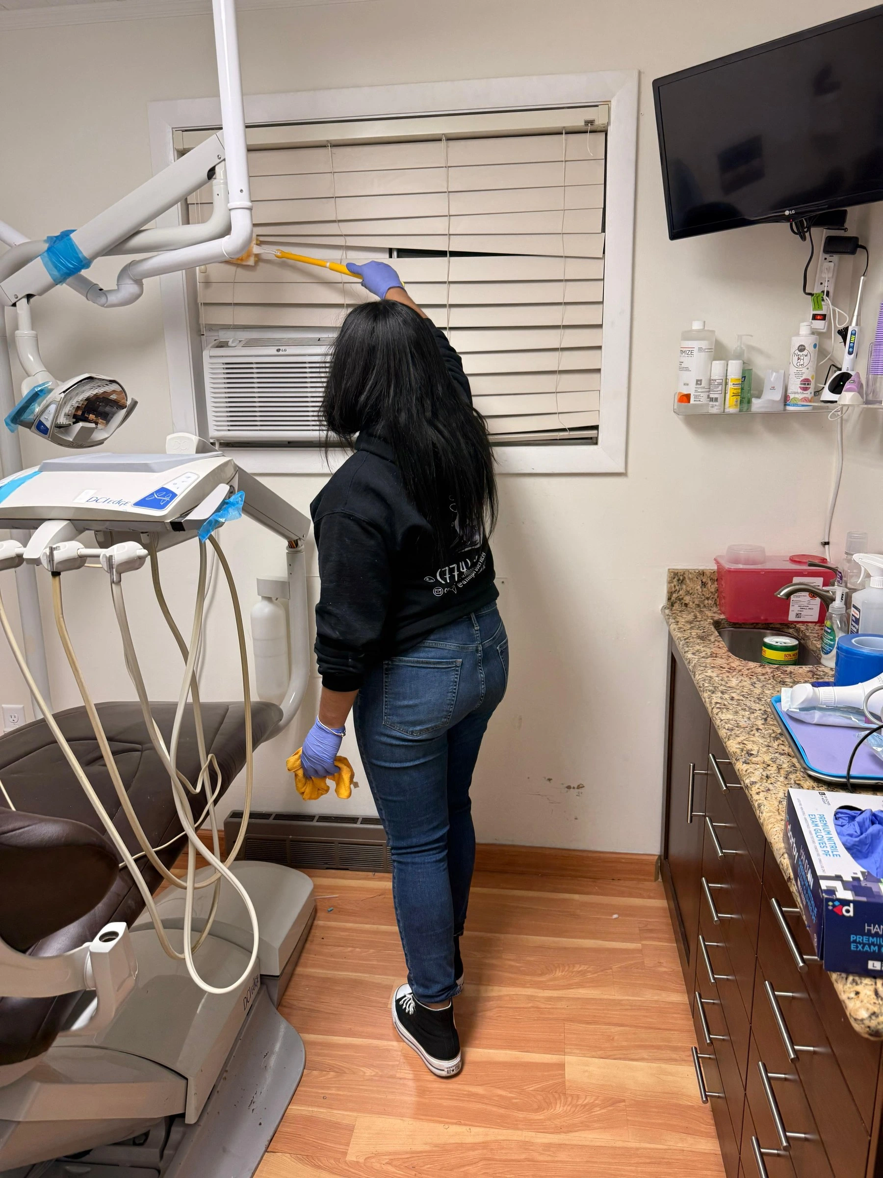 AMH team member dusting a dental office treatment room during commercial cleaning