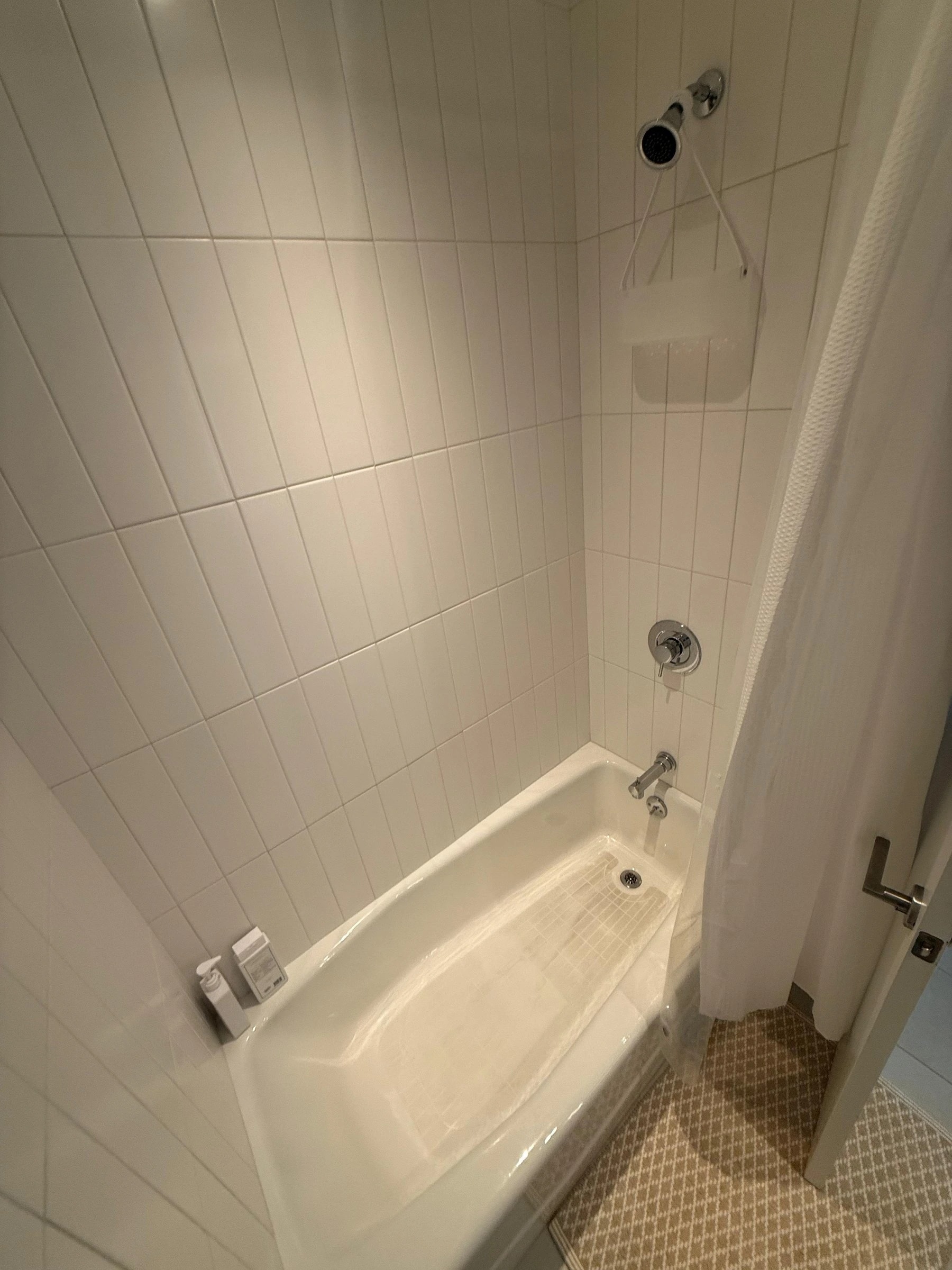 Spotless white bathtub and tiled shower walls after AMH deep cleaning
