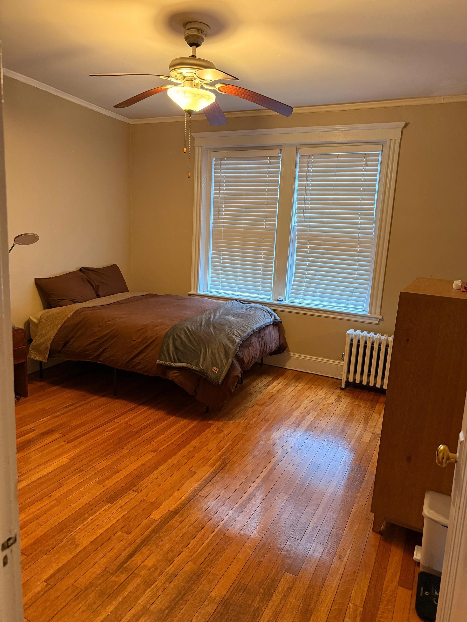 Tidy bedroom with gleaming hardwood floor after AMH residential cleaning