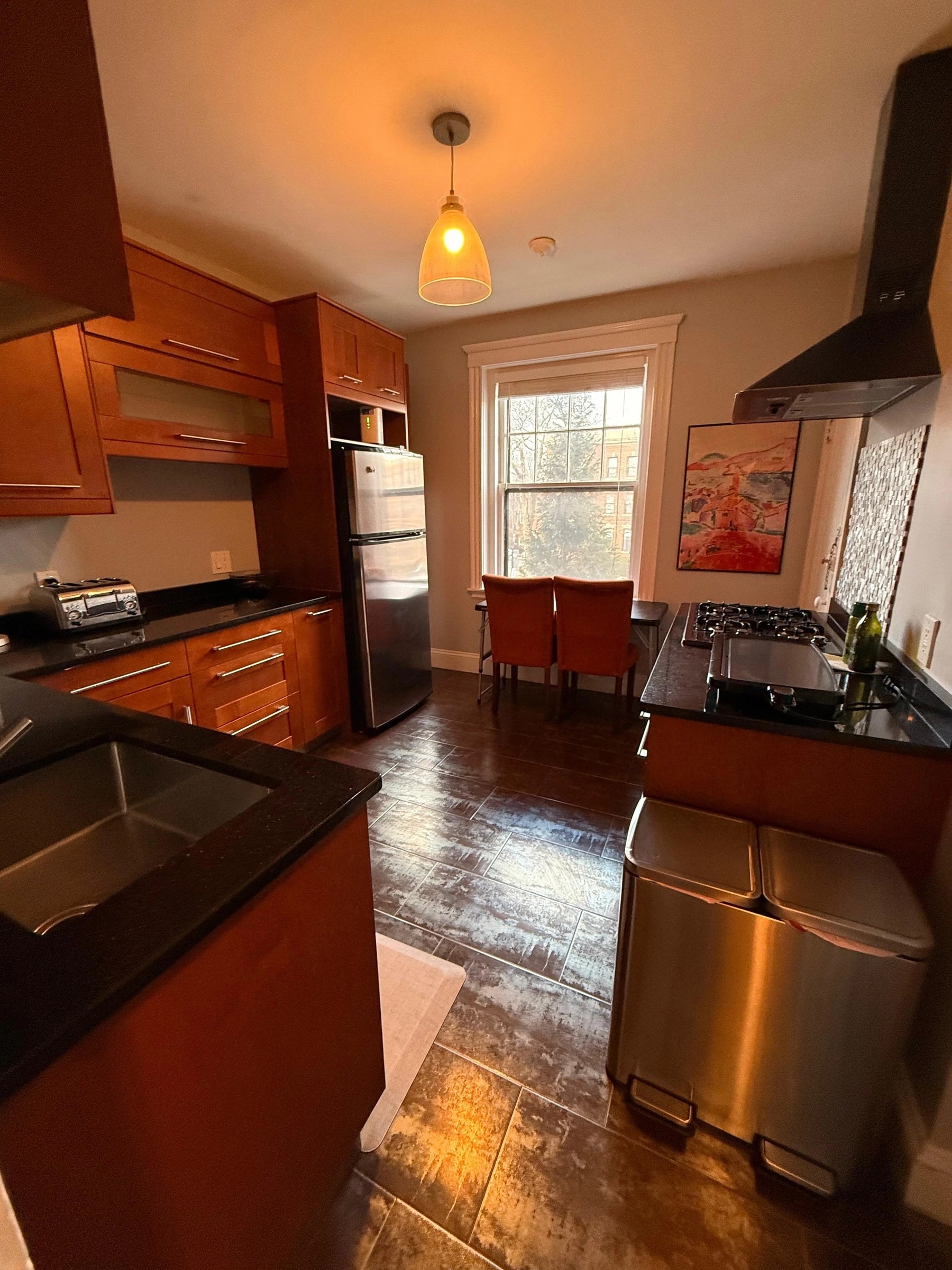 Clean apartment kitchen with polished hardwood floors after AMH house cleaning